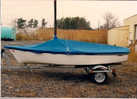 Small boat on trailer with blue boat cover